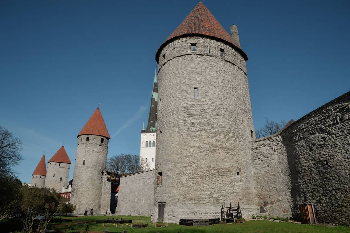 Tallinner Stadtmauer mit mehreren gut erhaltenen runden Wehrtürmen und massiven Steinmauern unter strahlend blauem Himmel – die mittelalterlichen Befestigungsanlagen rund um die Altstadt.