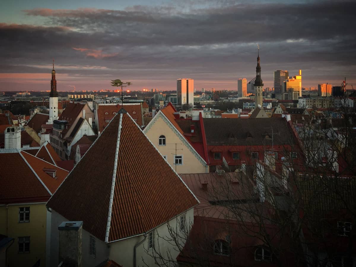 Rote Dächer und mittelalterliche Türme von Tallinn bei Sonnenuntergang mit dramatischem Himmel und Stadtsilhouette, von einem klassischen Aussichtspunkt der Altstadt aus gesehen
