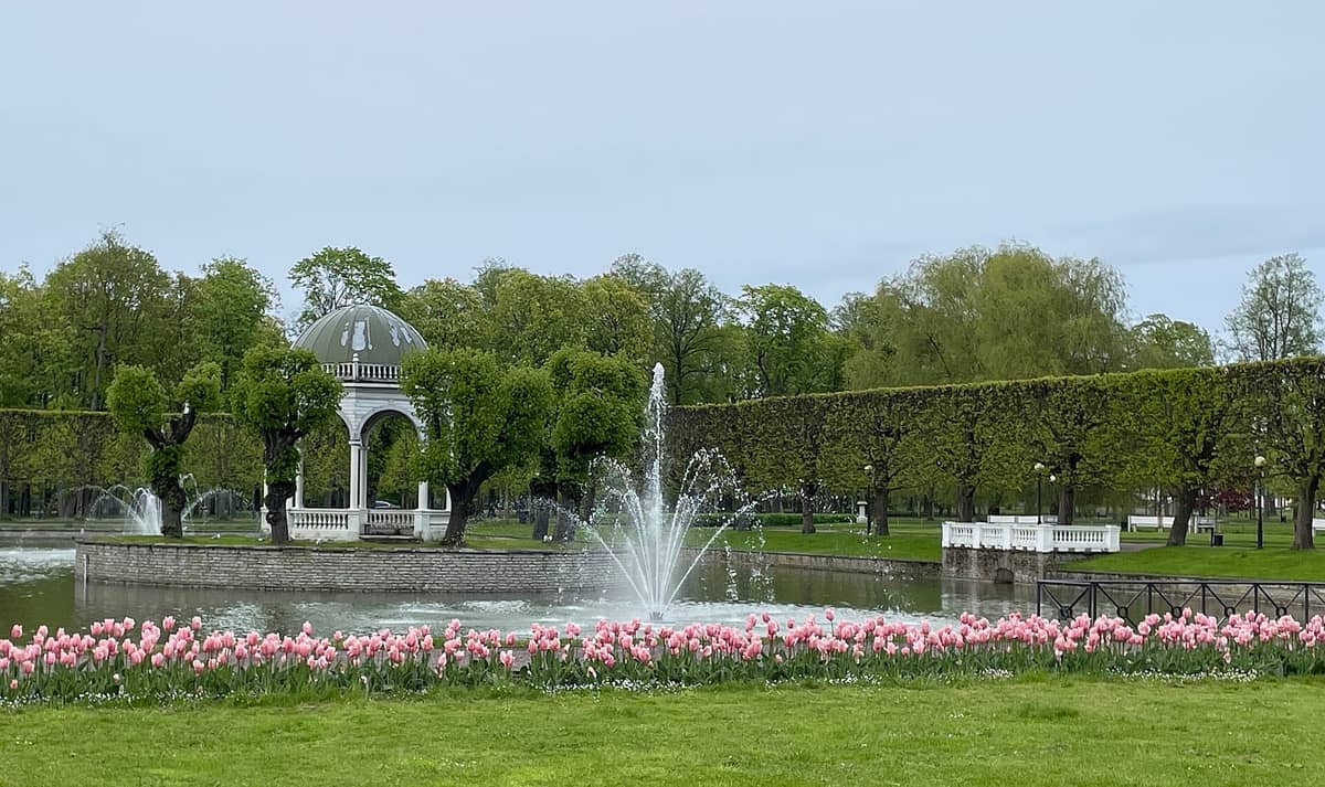 Der ikonische weiße Pavillon, der Brunnen, die Tulpenbeete und das gestaltete Grün des Kadriorg Parks im Frühling – eines der besten Familienziele im Freien in Tallinn.
