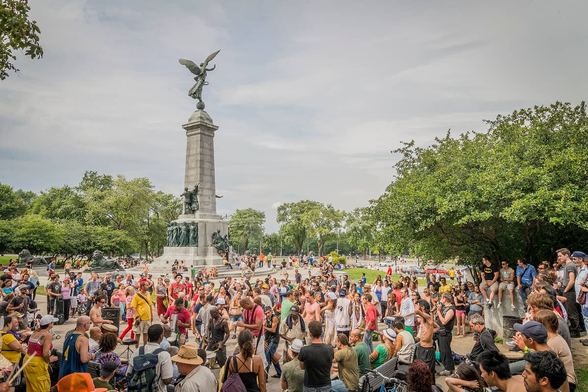 Eine große Menschengruppe versammelt sich um Trommler am George-Étienne Cartier Monument im Mont-Royal-Park während der Tam-Tams am Sonntag in Montréal.