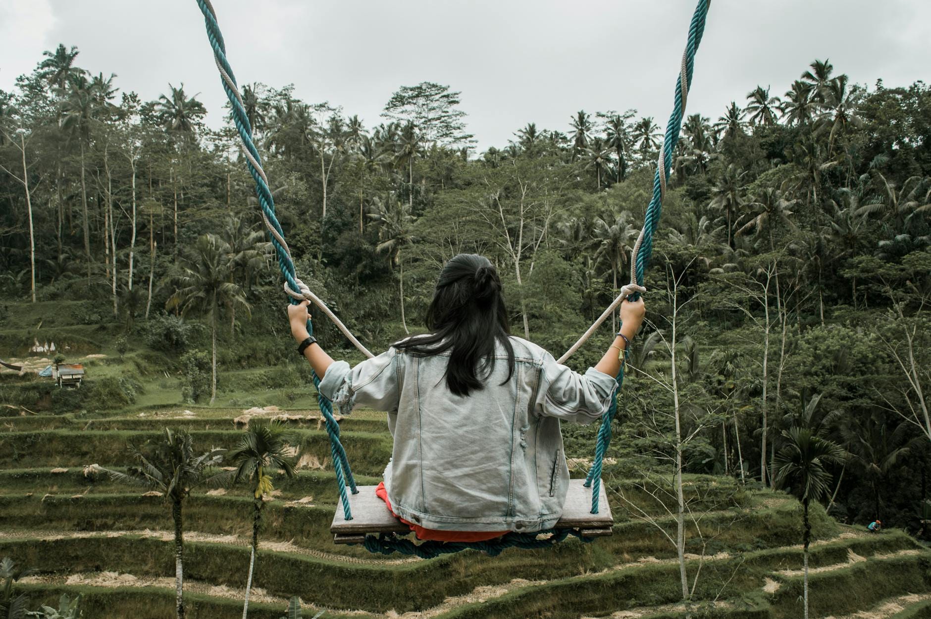 Donna seduta su un'altalena alle Terrazze di Riso di Tegallalang, Ubud