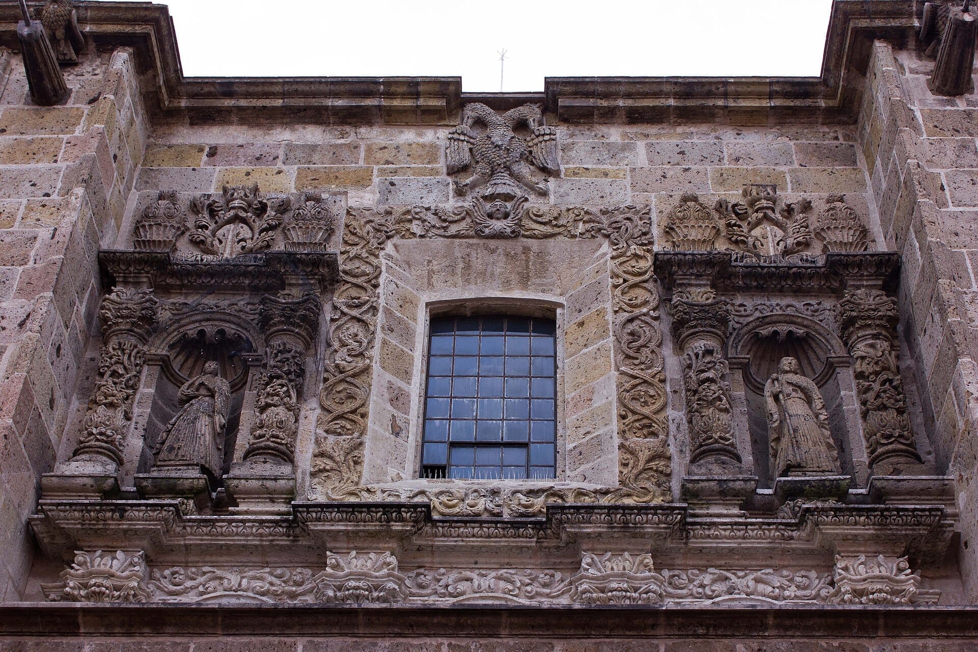 Intagli in pietra dettagliati e statue barocche adornano la facciata superiore del Templo de Santa Mónica nel centro storico di Guadalajara.