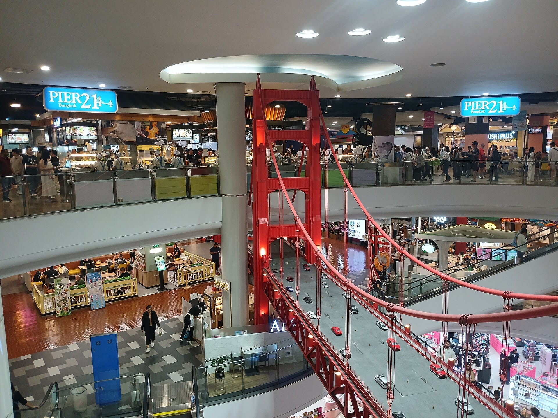 Interno del Terminal 21 a Bangkok con l'area ristoro Pier 21 e l'arredamento a tema ponte Golden Gate rosso