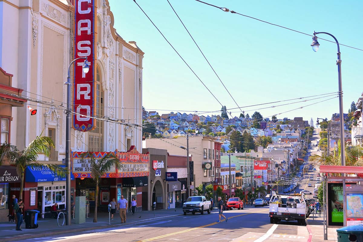 Vista de la calle Castro en San Francisco con el icónico marquesino del Castro Theatre, edificios coloridos y la calle Castro extendiéndose cuesta arriba.