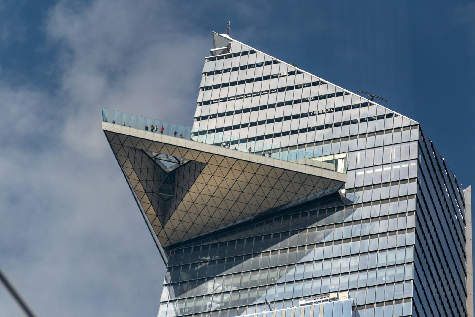 Vista ravvicinata del ponte di osservazione triangolare di Edge NYC che sporge dal grattacielo del 30 Hudson Yards su uno sfondo di cielo blu, con tutta la sua architettura spettacolare.