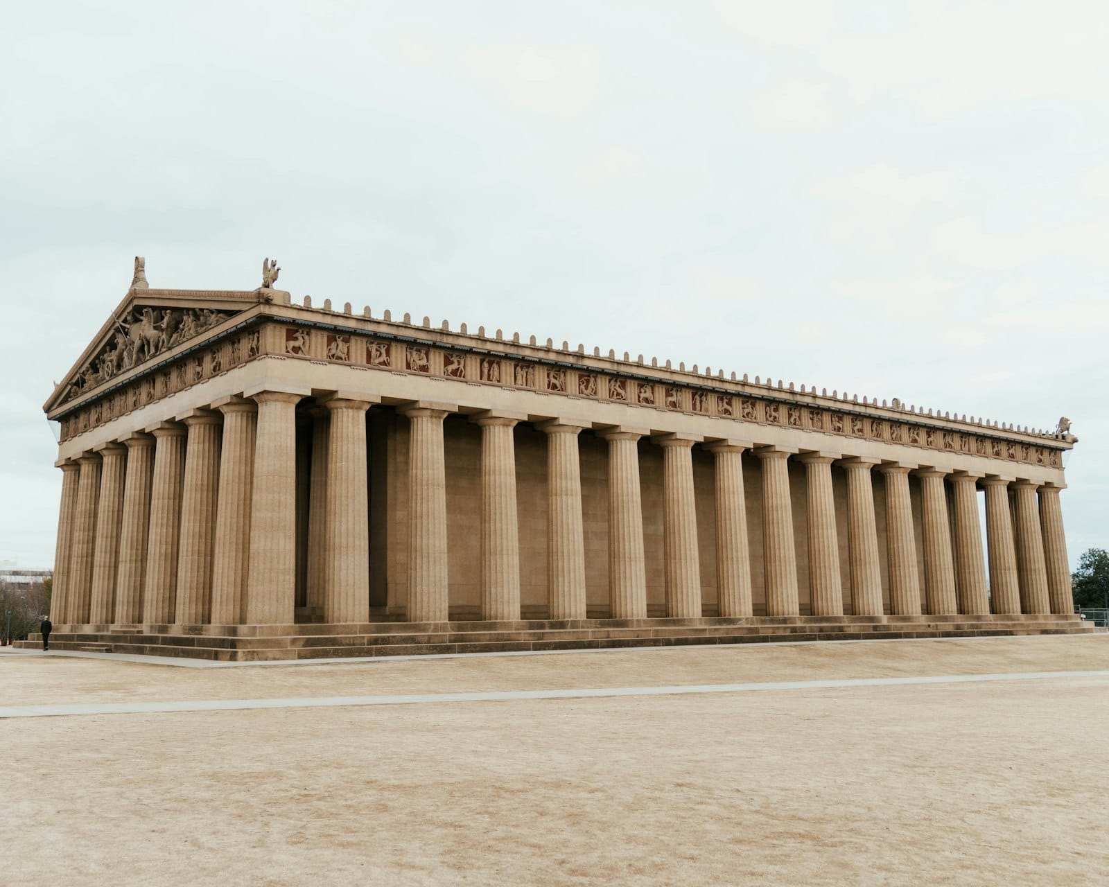 Vista panorámica del Partenón de Nashville a plena luz del día, con sus imponentes columnas dóricas a escala real y sus detalles arquitectónicos recortados contra un cielo despejado.