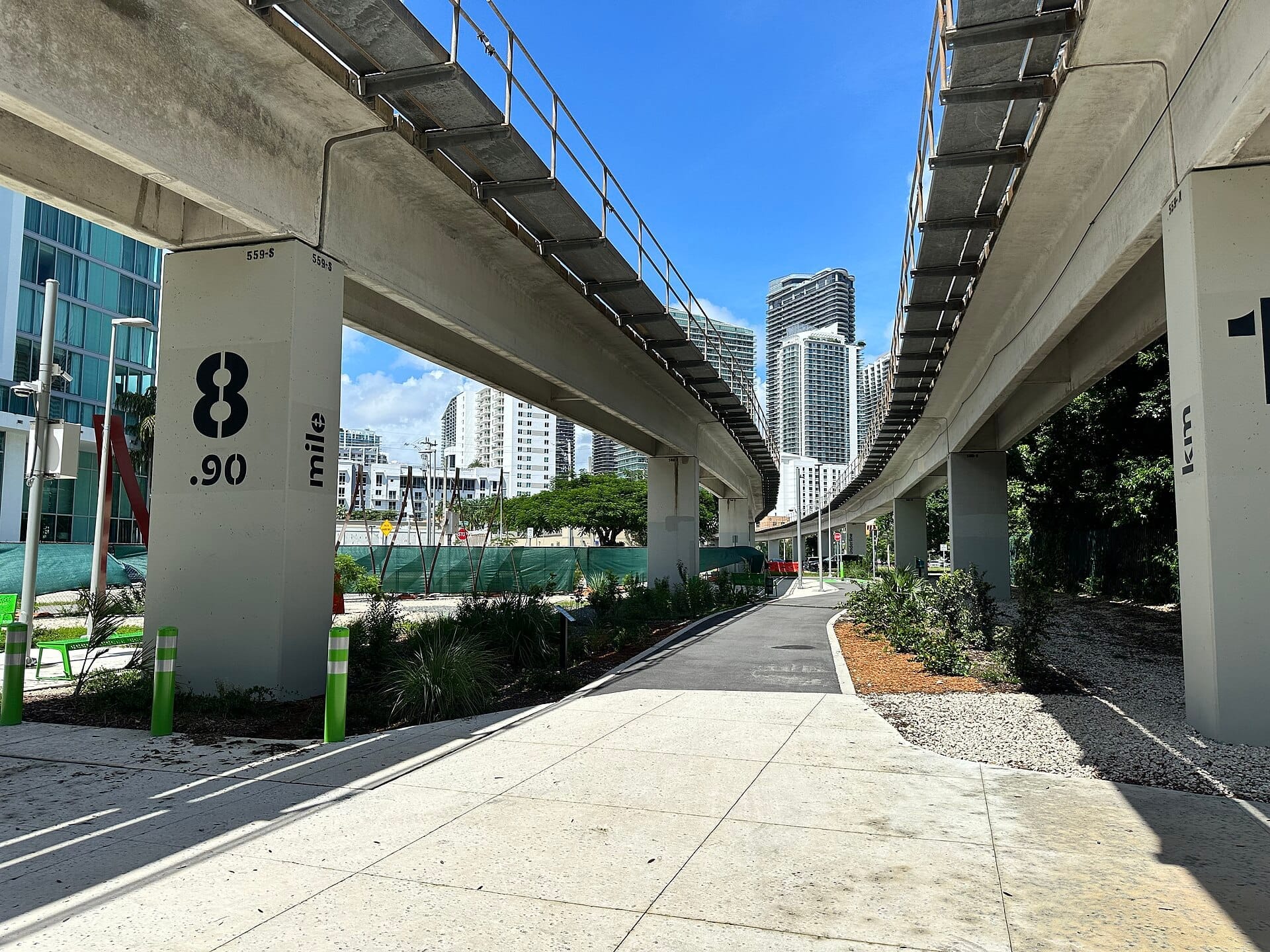Il percorso The Underline scorre sotto il Metrorail sopraelevato di Miami, circondato da verde, moderni grattacieli e cieli azzurri limpidi.