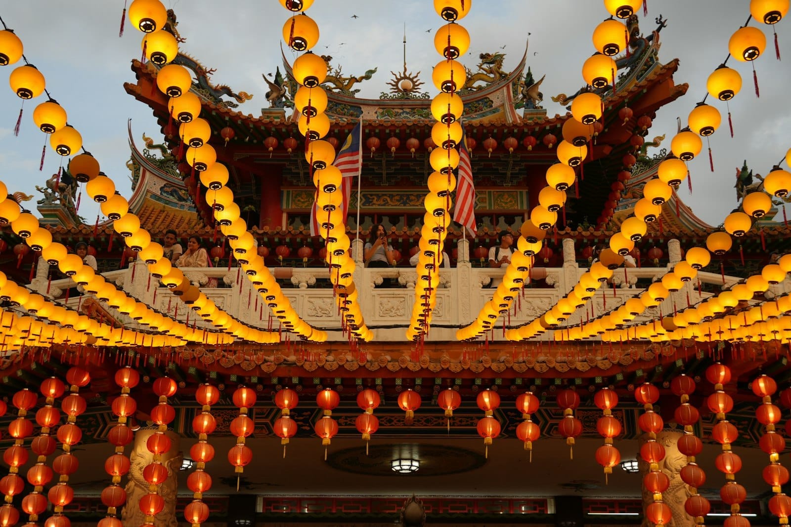 Ornate six-tiered **Thean Hou Temple** in Kuala Lumpur with red pillars, intricate roofs, and sweeping city skyline views from hilltop perch.