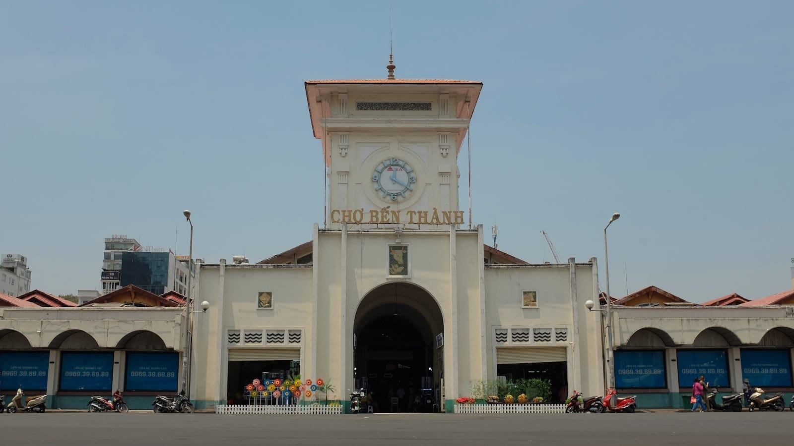 Vista frontal del Mercado Ben Thanh en Ho Chi Minh City, con su torre del reloj y entrada en un día despejado.