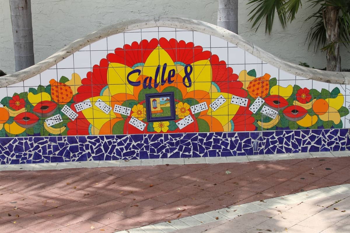 Colorful tiled mural reading 'Calle 8,' decorated with Cuban dominoes and fruit motifs in Little Havana, Miami.