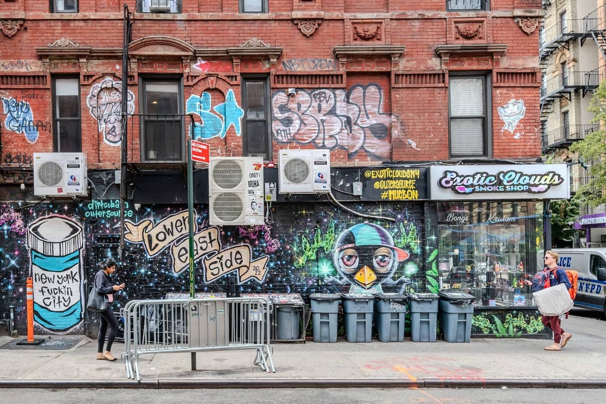Rote Backsteinmiethäuser und Ladenfronten mit bunter Straßenkunst und Graffiti im Lower East Side von Manhattan, New York City.