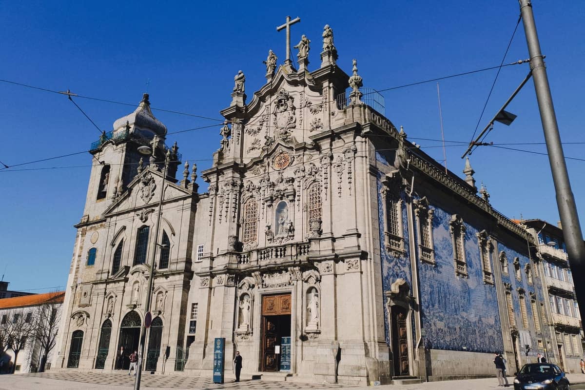 Facciata barocca della Igreja do Carmo con elaborate decorazioni in pietra e piastrelle azulejo blu, su un cielo azzurro limpido a Porto, Portogallo.