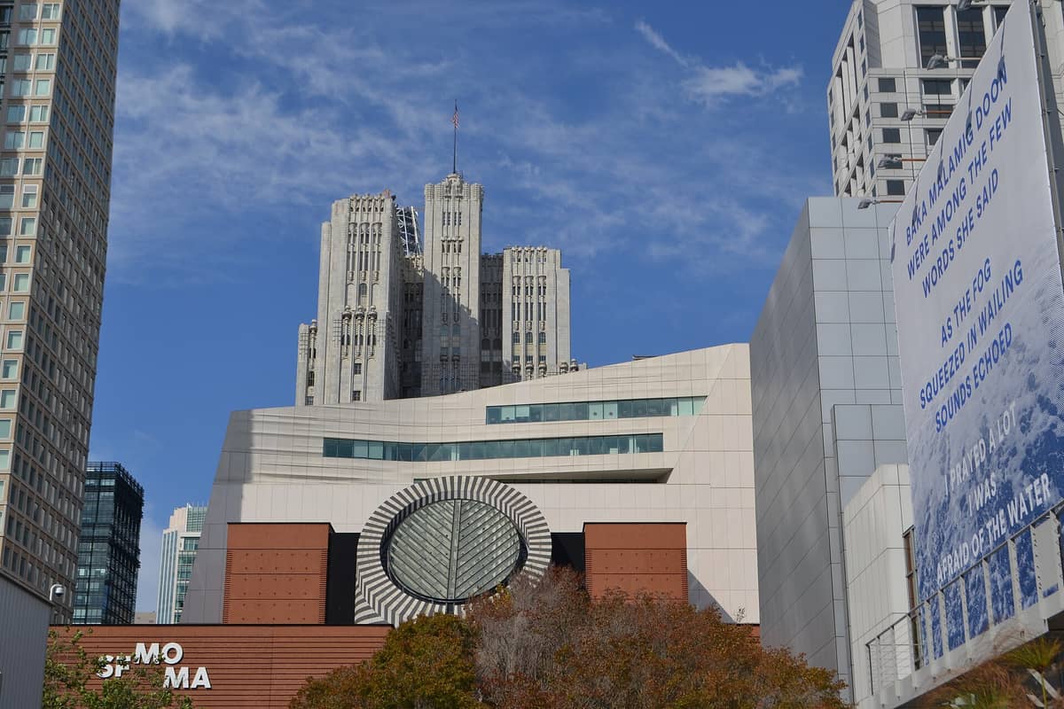 Außenansicht des San Francisco Museum of Modern Art mit seinem ikonischen Rundfenster und umliegenden Stadtgebäuden unter blauem Himmel