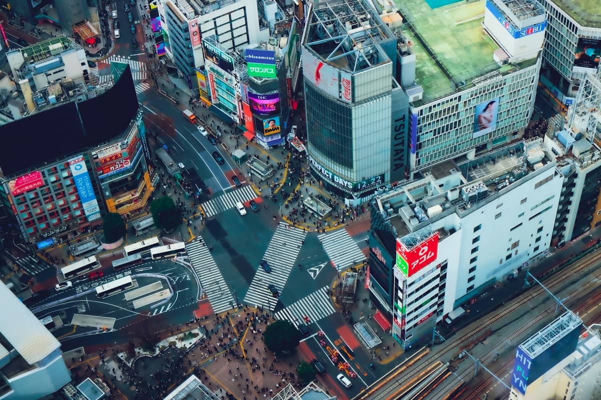 Aerial view of Shibuya Crossing and surrounding buildings in central Tokyo, highlighting the vibrant urban neighborhoods and busy streets.