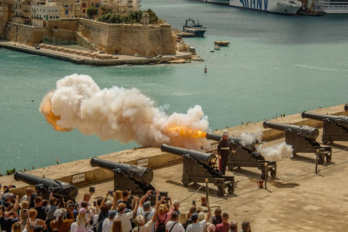 Tłum obserwujący wystrzał armatni w Upper Barrakka Gardens z widokiem na Grand Harbour w Valletcie, Malta.