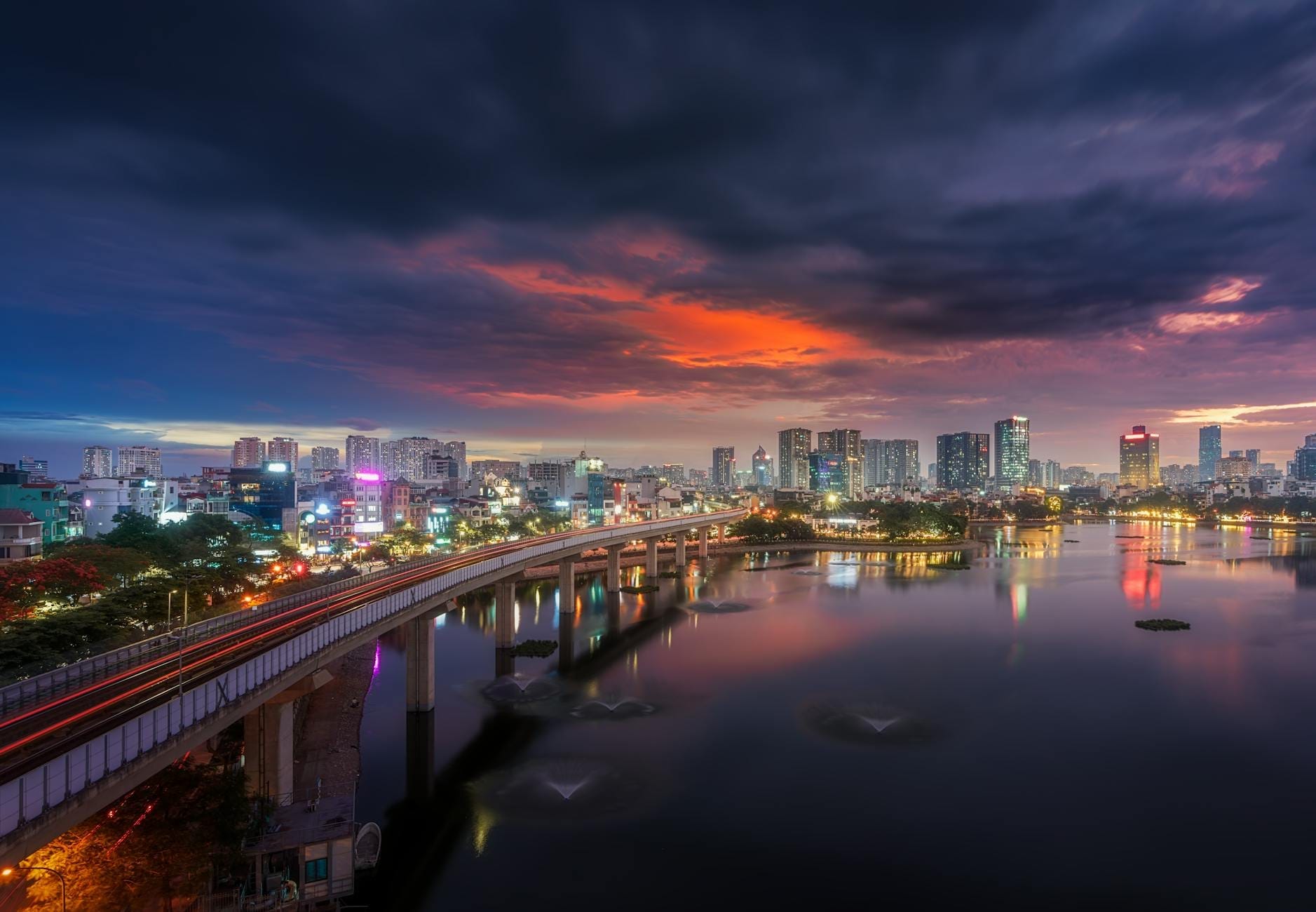 วิวพระอาทิตย์ตกเหนือแม่น้ำเจ้าพระยาฝั่งธนบุรี พร้อมสะพานและสกายไลน์ของกรุงเทพฯ