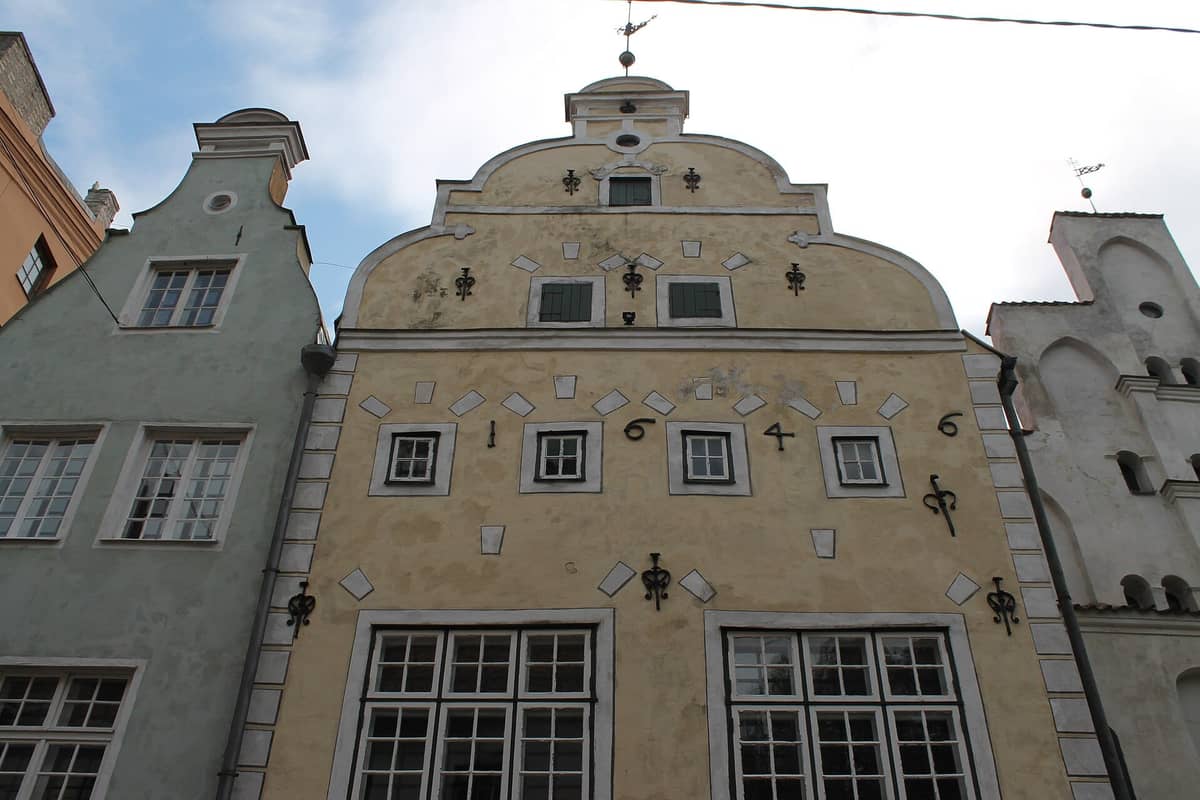 Fassaden der historischen Drei-Brüder-Häuser in Riga mit ihren unterschiedlichen Architekturstilen und pastellfarbenen Fassaden im Tageslicht.