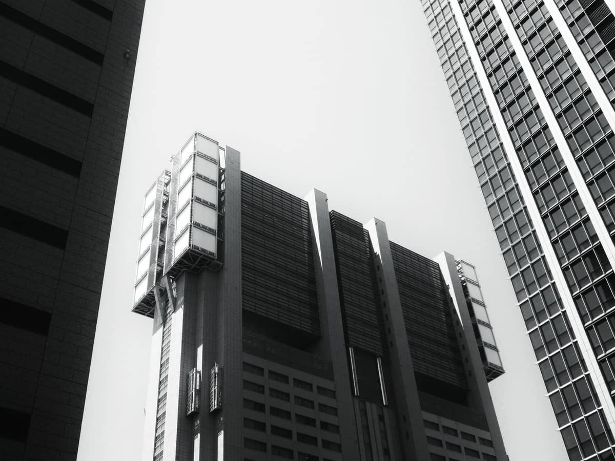 Black and white photo looking up at Tokyo Metropolitan Government Building, with geometric forms evoking late 20th-century architectural styles.