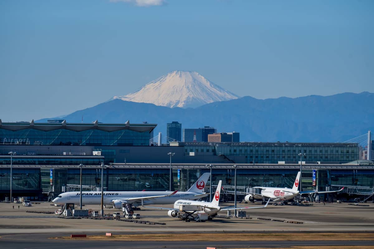 Planes at terminal at Tokyo airport with Mt Fuji in the background on a clear day