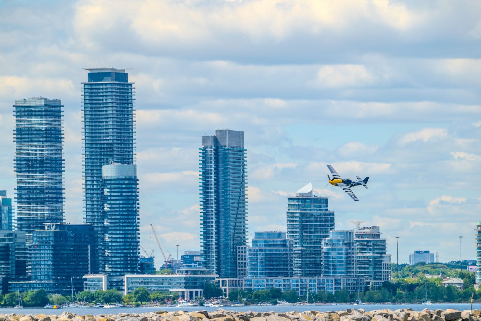 Um pequeno avião comercial decolando em frente ao horizonte de Toronto, representando a localização do Billy Bishop Toronto City Airport.