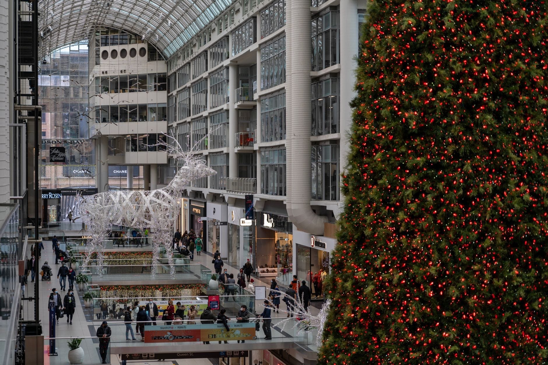 ภาพภายใน CF Toronto Eaton Centre มุมกว้าง เห็นหลังคากระจกสูง ร้านค้าหลายชั้น นักช้อป และต้นคริสต์มาสตกแต่งขนาดใหญ่