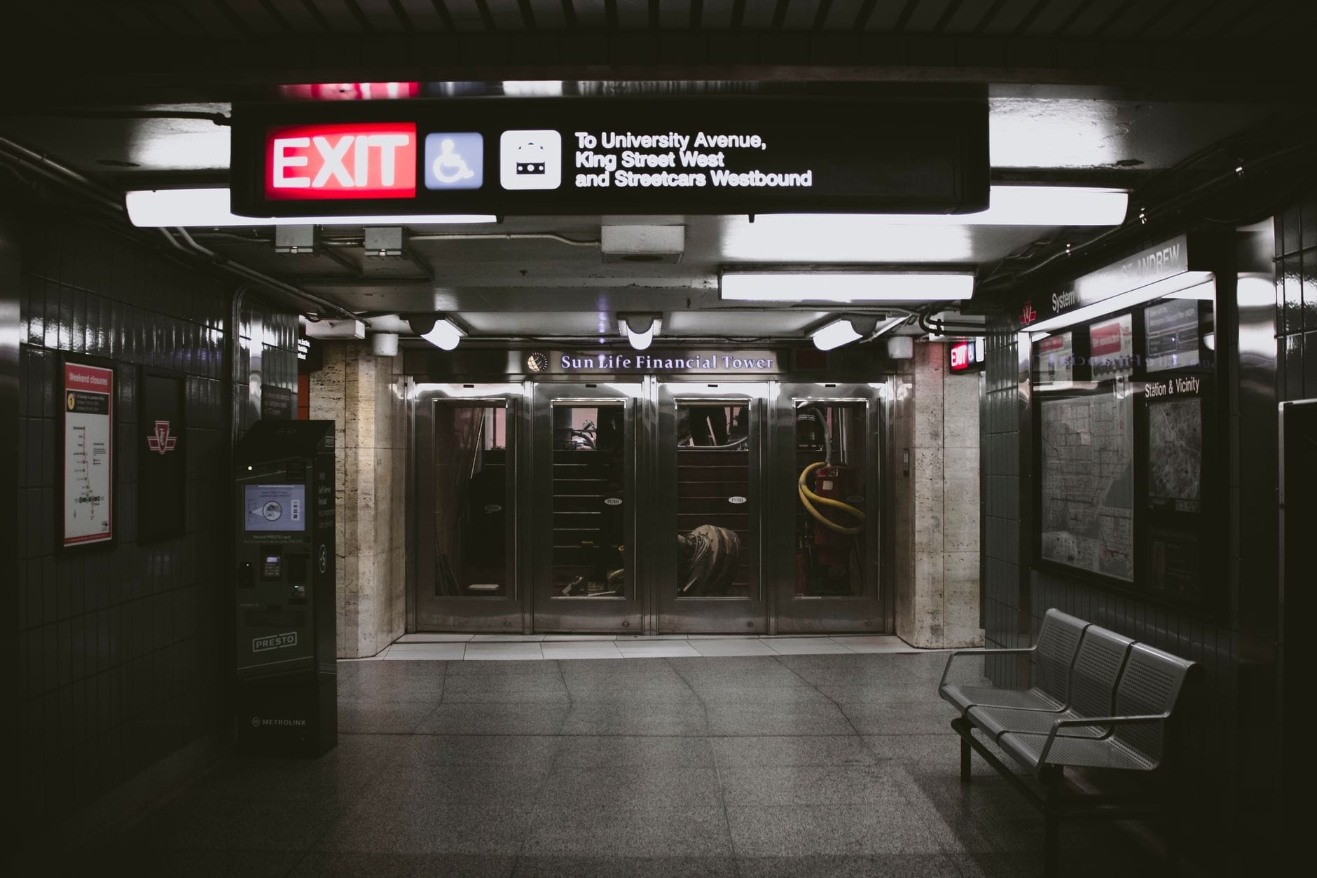 Uma passagem subterrânea moderna e limpa com sinalização para University Avenue e King Street West, típica da rede pedonal do centro de Toronto.
