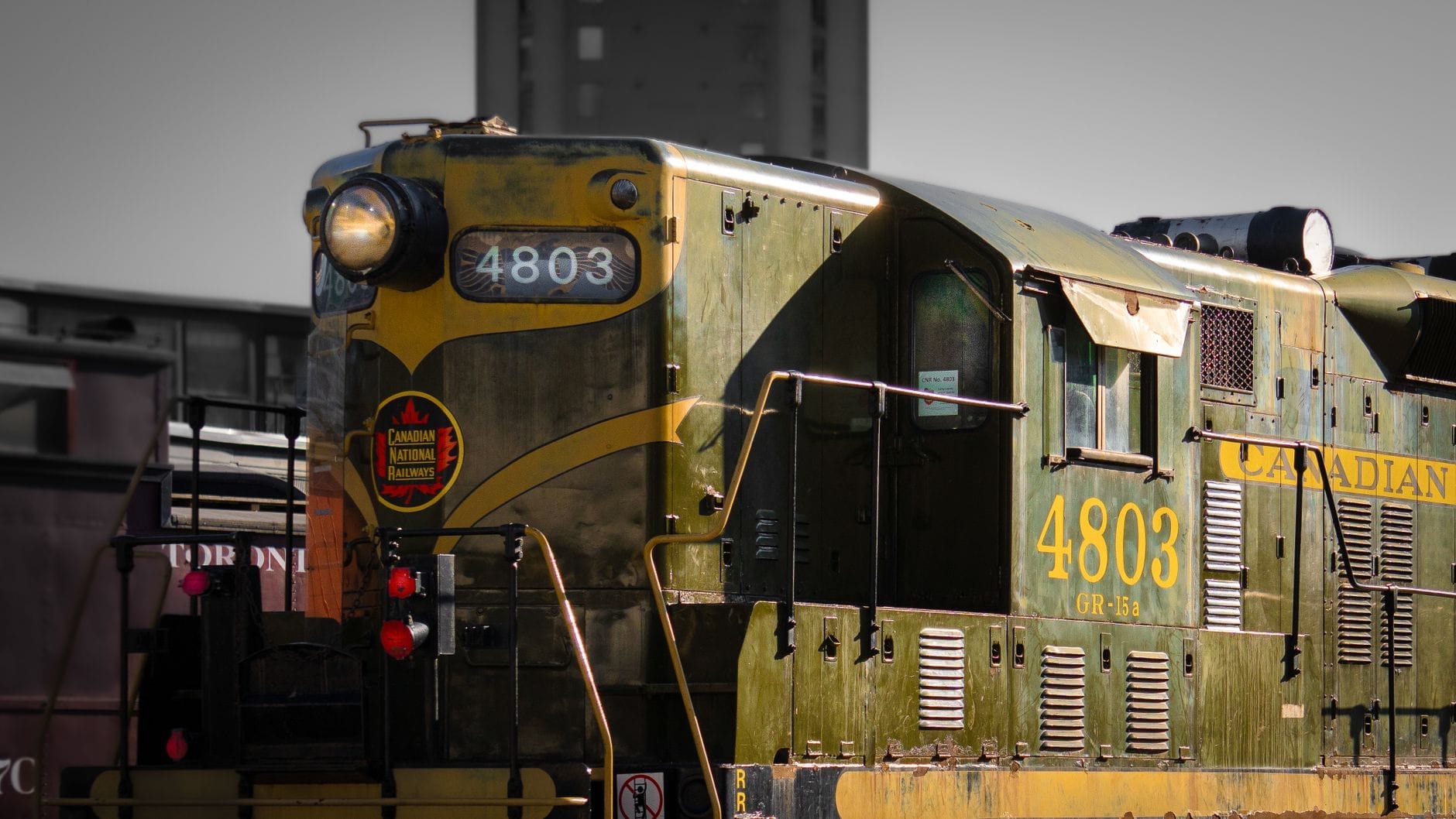 หัวรถจักรดีเซล Canadian National 4803 โบราณที่บูรณะใหม่ ตั้งอยู่นอกอาคารท่ามกลางแสงแดด โชว์รายละเอียดประวัติศาสตร์ของรถไฟในบรรยากาศพิพิธภัณฑ์