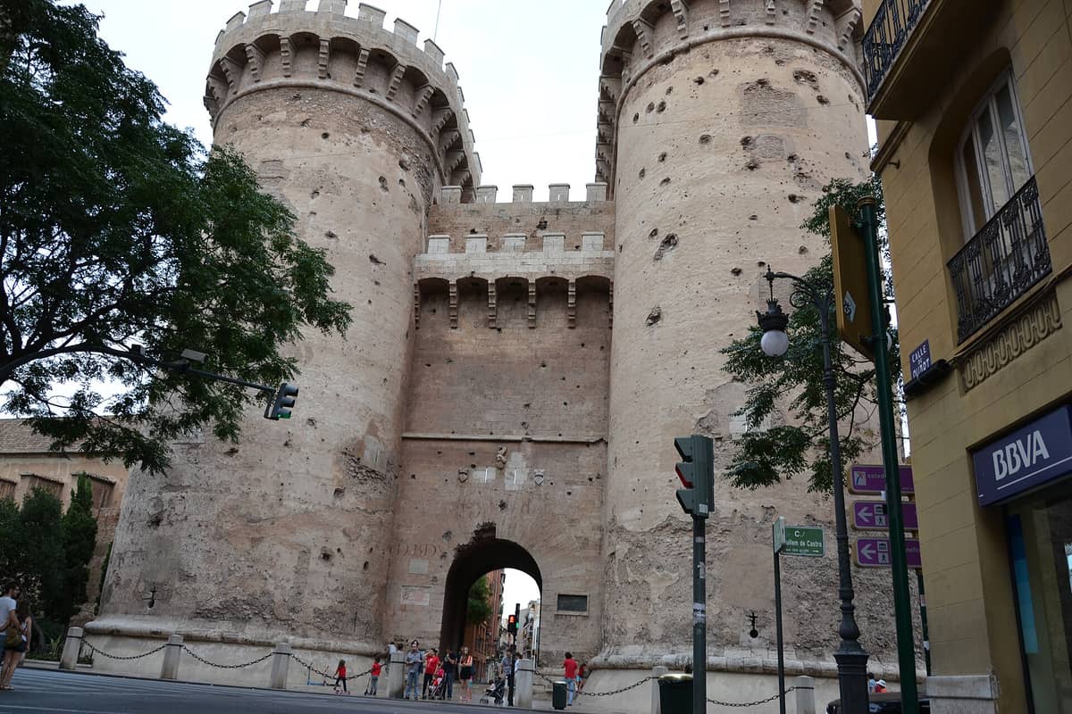 Frontansicht der zweitürmigen Torres de Quart in Valencia mit gut sichtbaren Kanonenkugelnarben an den mittelalterlichen Steintürmen.