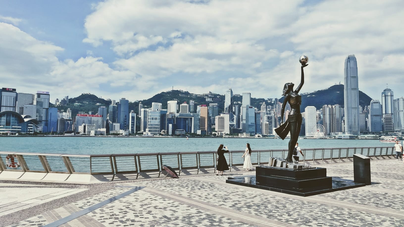 รูปปั้น Avenue of Stars และสกายไลน์ฮ่องกงจากริมน้ำจิมซาจุ่ยที่ Victoria Harbour
