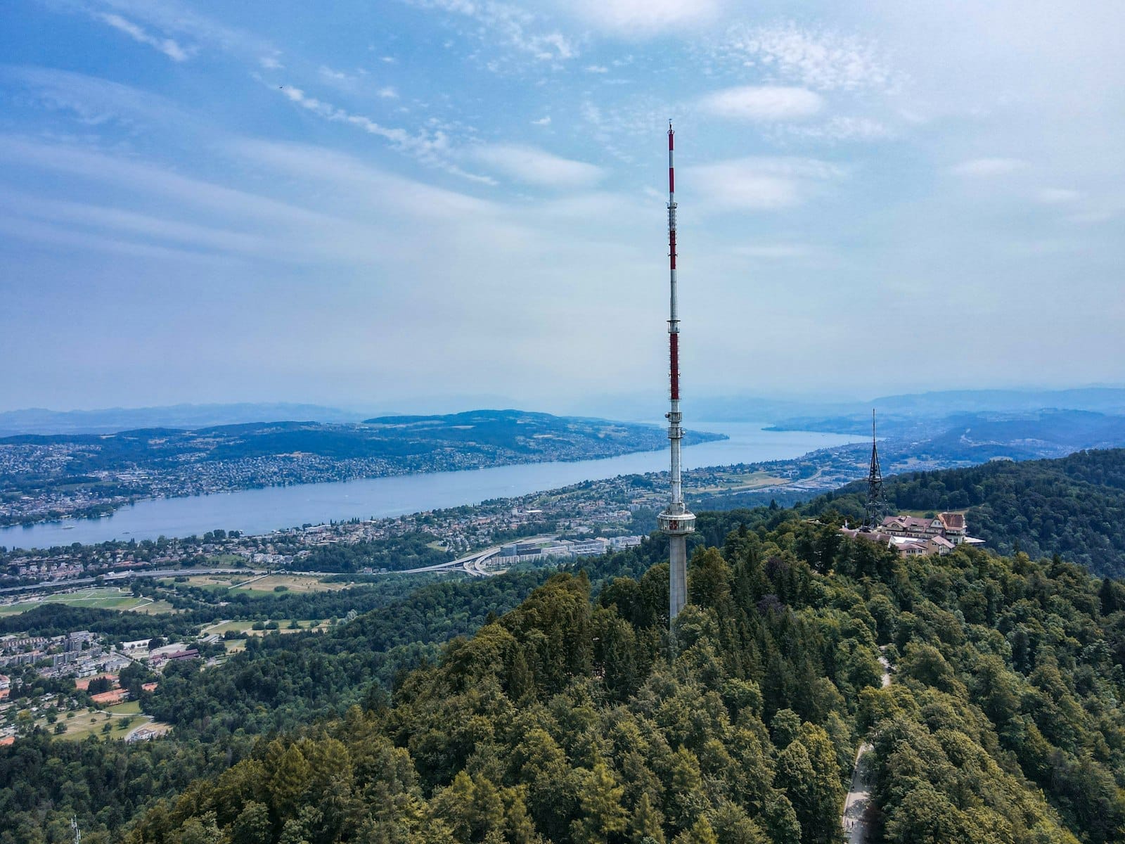 ยอดเขา Uetliberg พร้อมหอดูดาว ป่าเขียวชอุ่ม และวิวกว้างไกลเหนือทะเลสาบ Zurich และเมืองใต้ท้องฟ้าสีฟ้าสดใส