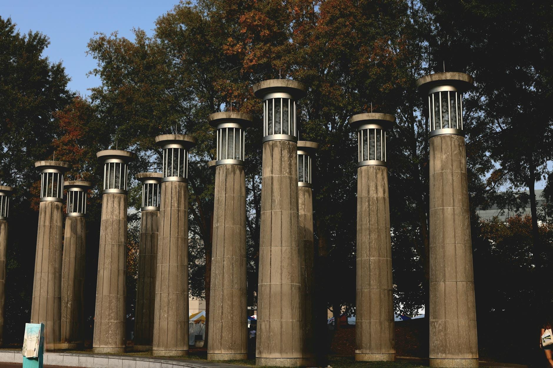 Fila de inusuales pilares de piedra con remates de farol en el exterior, rodeados de árboles en Nashville.