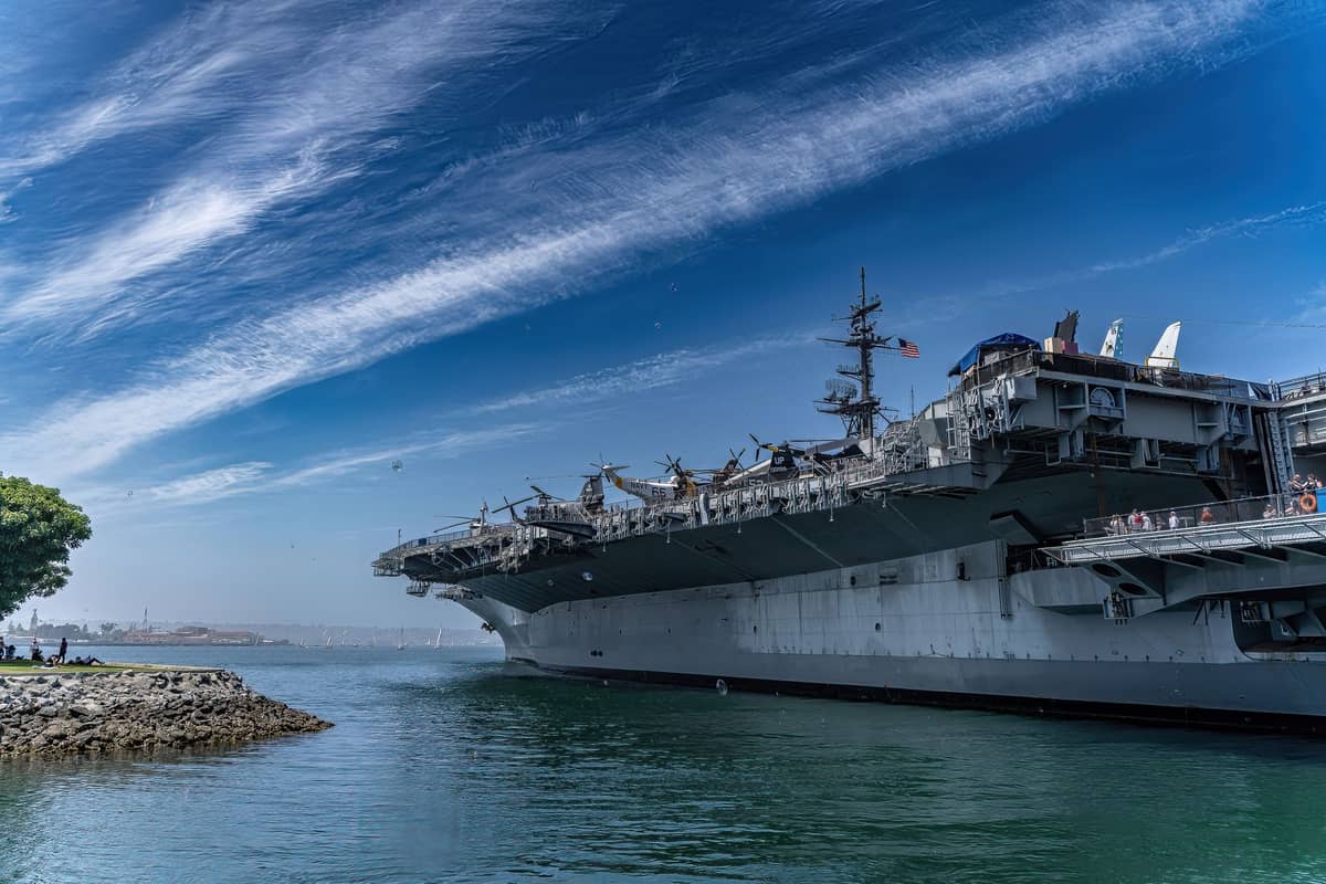 เรือบรรทุกเครื่องบิน USS Midway จอดเทียบท่าริมน้ำซานดิเอโกใต้ท้องฟ้าสีสด พร้อมเครื่องบินจัดแสดงบนดาดฟ้า