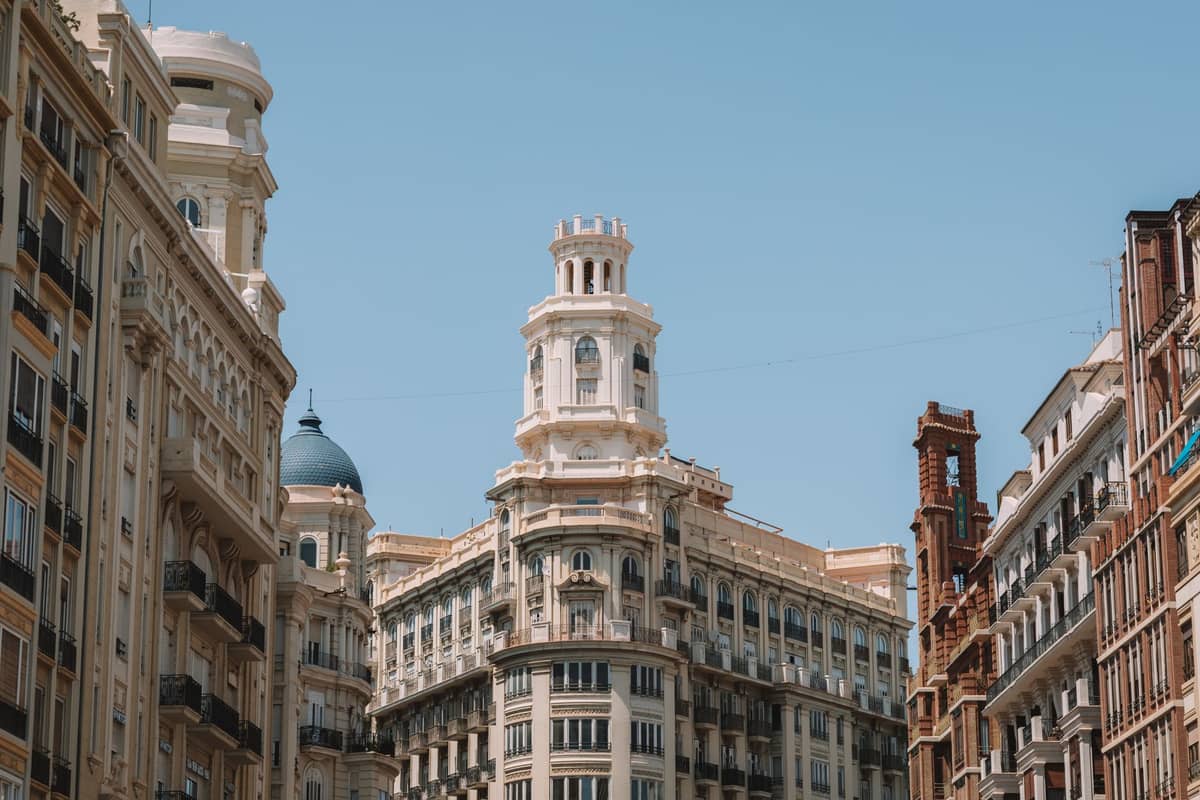 Edifici del centro di Valencia Spagna illuminati dal sole sotto un cielo blu limpido estivo, che mostrano luce, calore e paesaggio urbano mediterraneo.