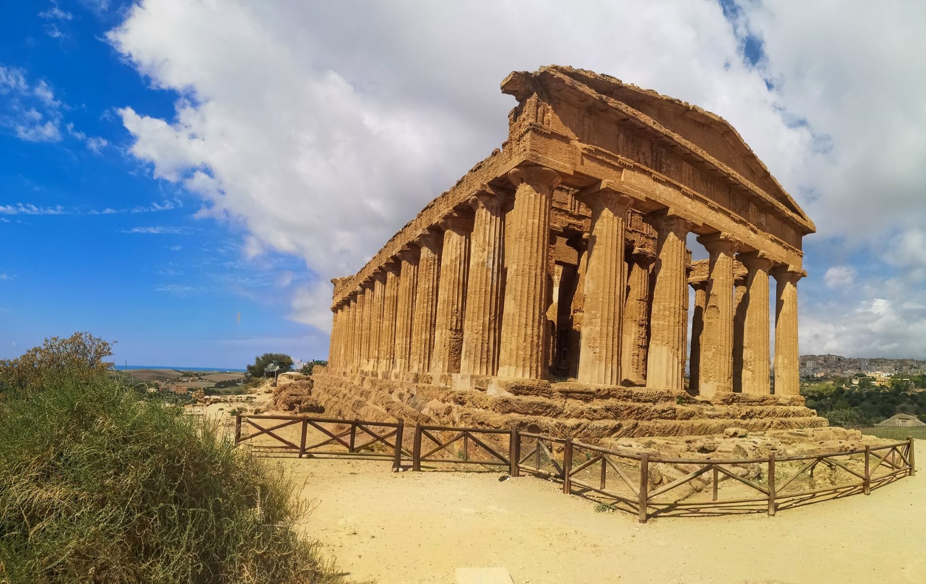 Panoramablick auf den gut erhaltenen antiken griechischen Concordia-Tempel unter einem leuchtend blauen Himmel mit vereinzelten Wolken im Tal der Tempel, Agrigent.