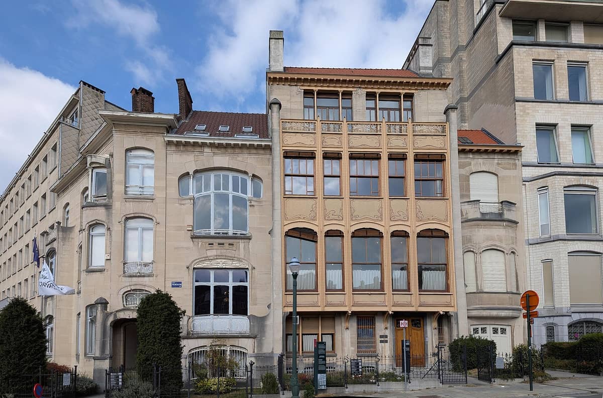 Fachada do Hôtel Van Eetvelde em Bruxelas com seu icônico design Art Nouveau e janelas ornamentadas sob um céu azul.