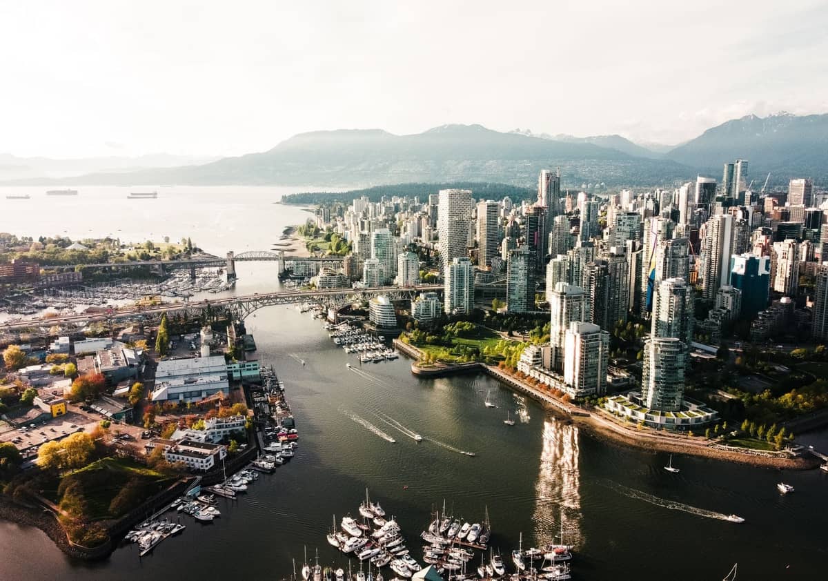Luftaufnahme von Vancouver mit mehreren markanten Stadtvierteln, der Skyline der Innenstadt und Wasserwegen an einem klaren Tag.