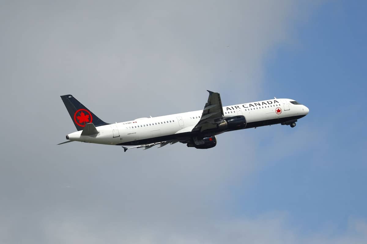 เครื่องบิน Air Canada กำลังขึ้นบินท่ามกลางท้องฟ้ามีเมฆ สื่อถึงเที่ยวบินจาก Vancouver ไป Calgary