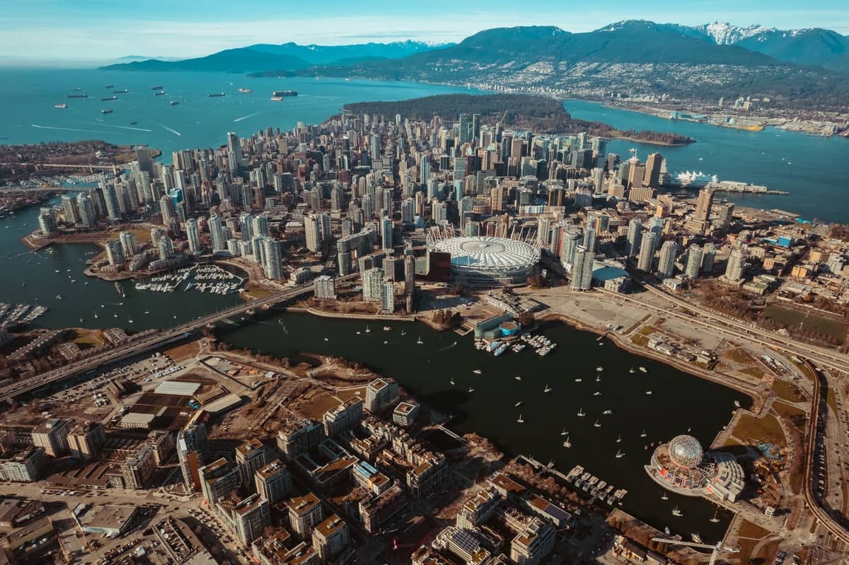 Luftaufnahme von Vancouver mit Stadtsilhouette, Uferpromenade und Bergen, die den wichtigsten Reisekorridor nach Süden hervorheben.