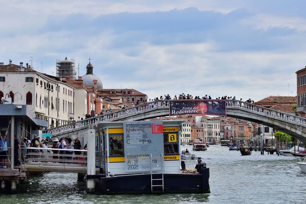 Blick auf die Vaporetto-Haltestelle am Venediger Lido mit Bogenbrücke und Festivalfahnen – zentrale Orte rund um das Filmfestival Venedig.