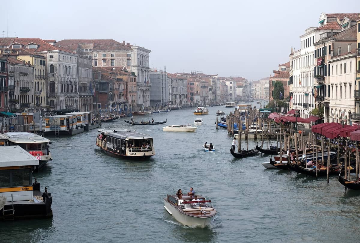 Belebter Canal Grande in Venedig mit Wasserbussen, Gondeln und historischen Gebäuden auf beiden Seiten bei Tag
