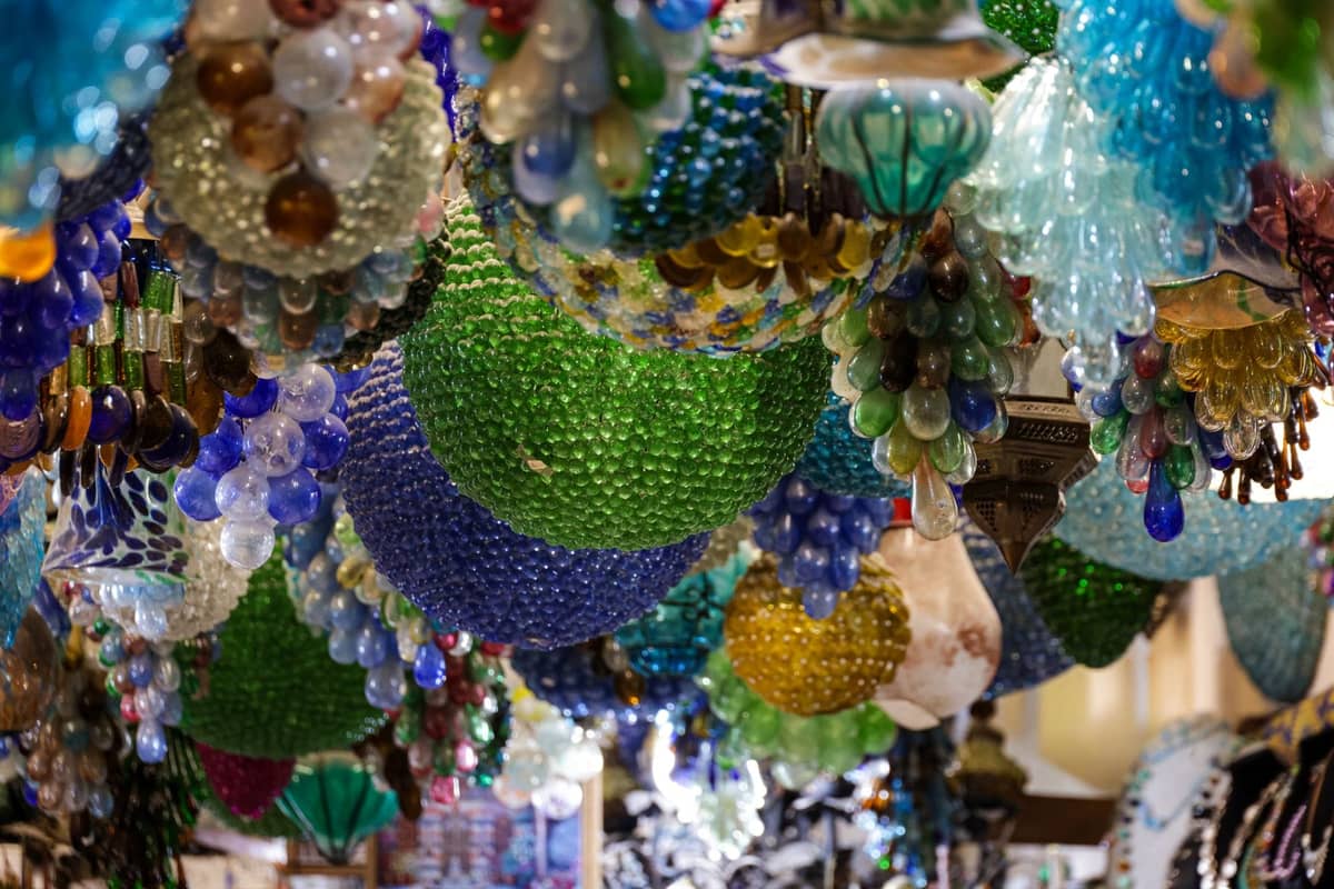 Bunte handgefertigte Murano-Glas-Kronleuchter und Ornamente, die dicht beieinander in einem venezianischen Geschäft hängen.