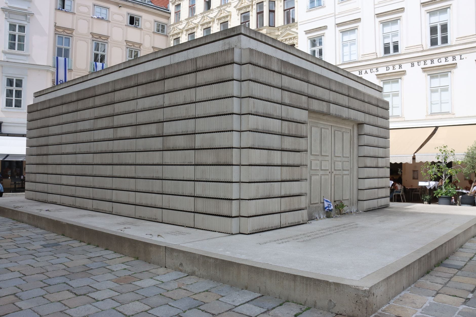 Holocaust-Mahnmal am Wiener Judenplatz, eine Betonwürfelstruktur, umgeben von historischen Gebäuden und Kopfsteinpflaster.