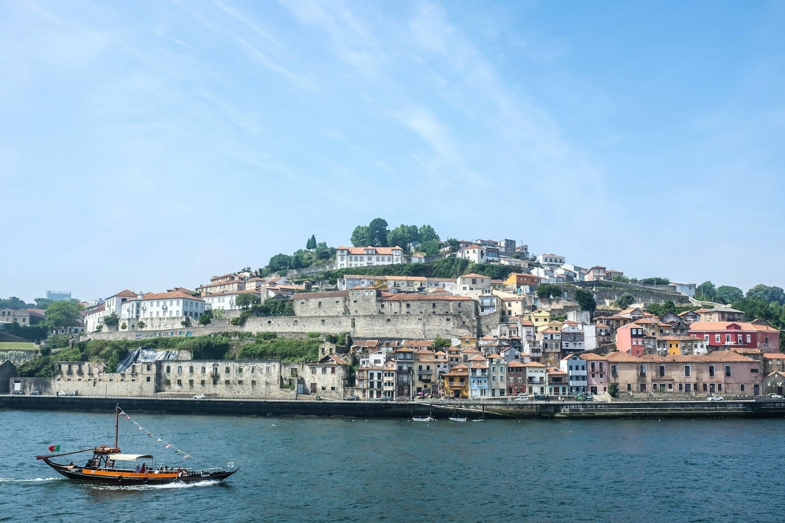 วิวเนินและอาคารประวัติศาสตร์ของ Vila Nova de Gaia กับแม่น้ำโดรูและเรือ rabelo ใต้แสงแดด
