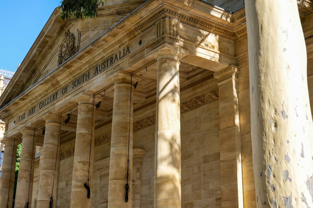 Facade of the Art Gallery of South Australia with tall columns and sunlight on the sandstone entrance