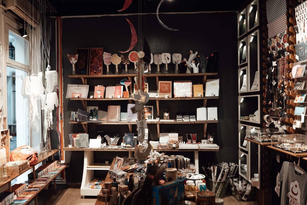Nội thất của một cửa hàng boutique phong cách trưng bày nghệ thuật, đồ thủ công, sách và quà lưu niệm độc đáo trên kệ và bàn.