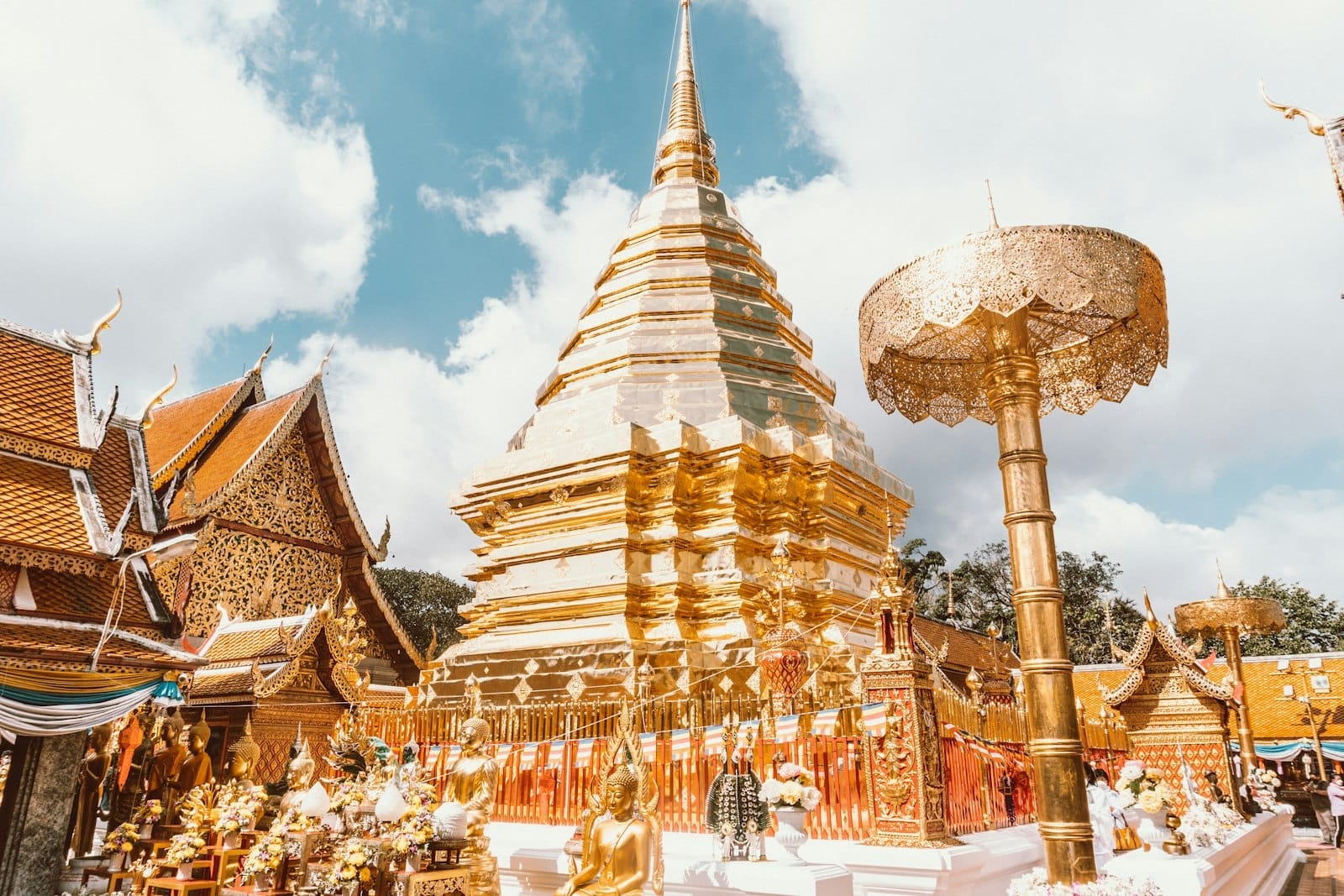 Complesso templare del Wat Pho a Bangkok con chedi bianchi e architettura tradizionale thailandese sotto un cielo azzurro