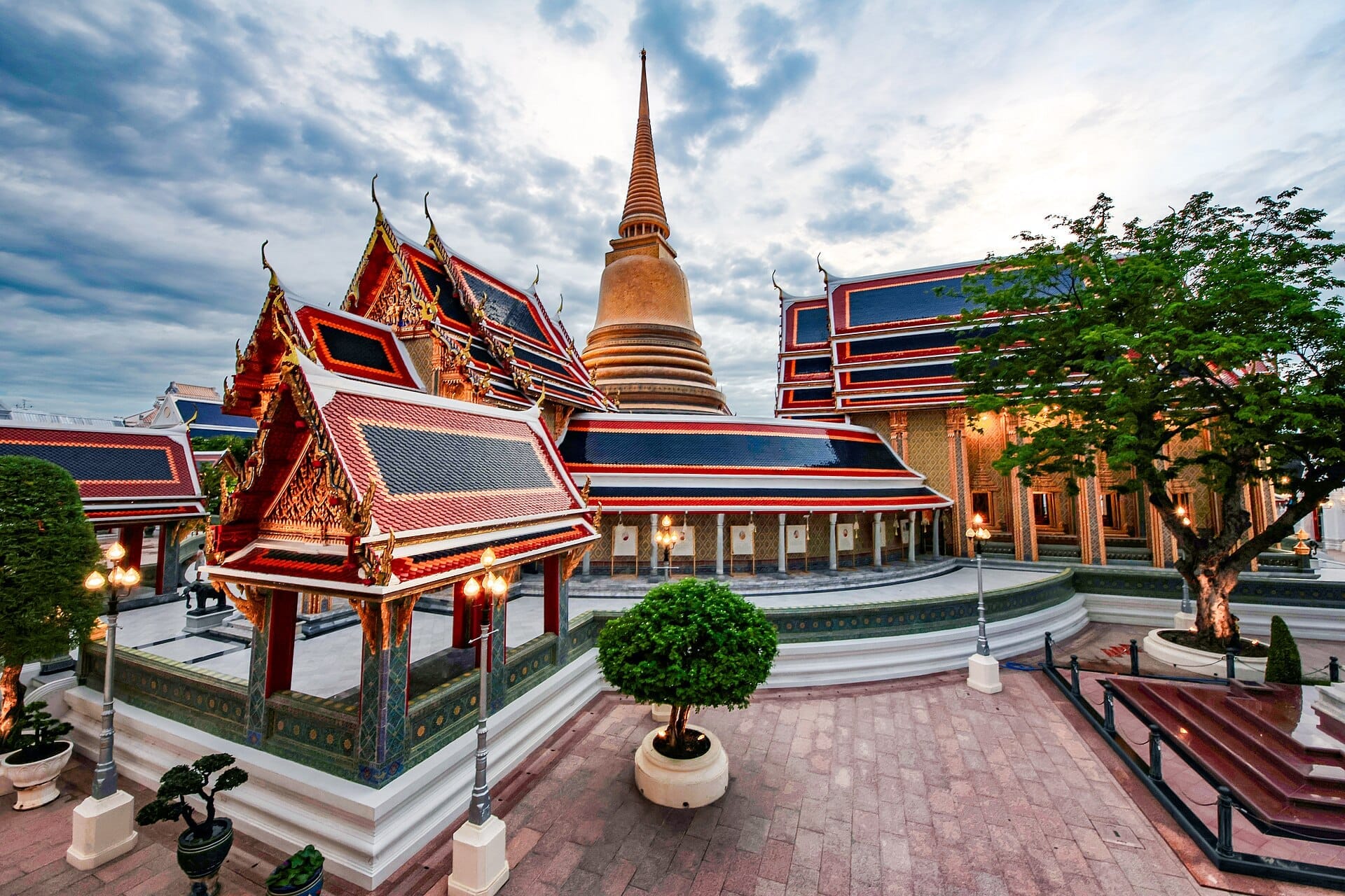 Cortile del tempio Wat Ratchabophit a Bangkok con chedi dorato centrale e architettura thai circostante
