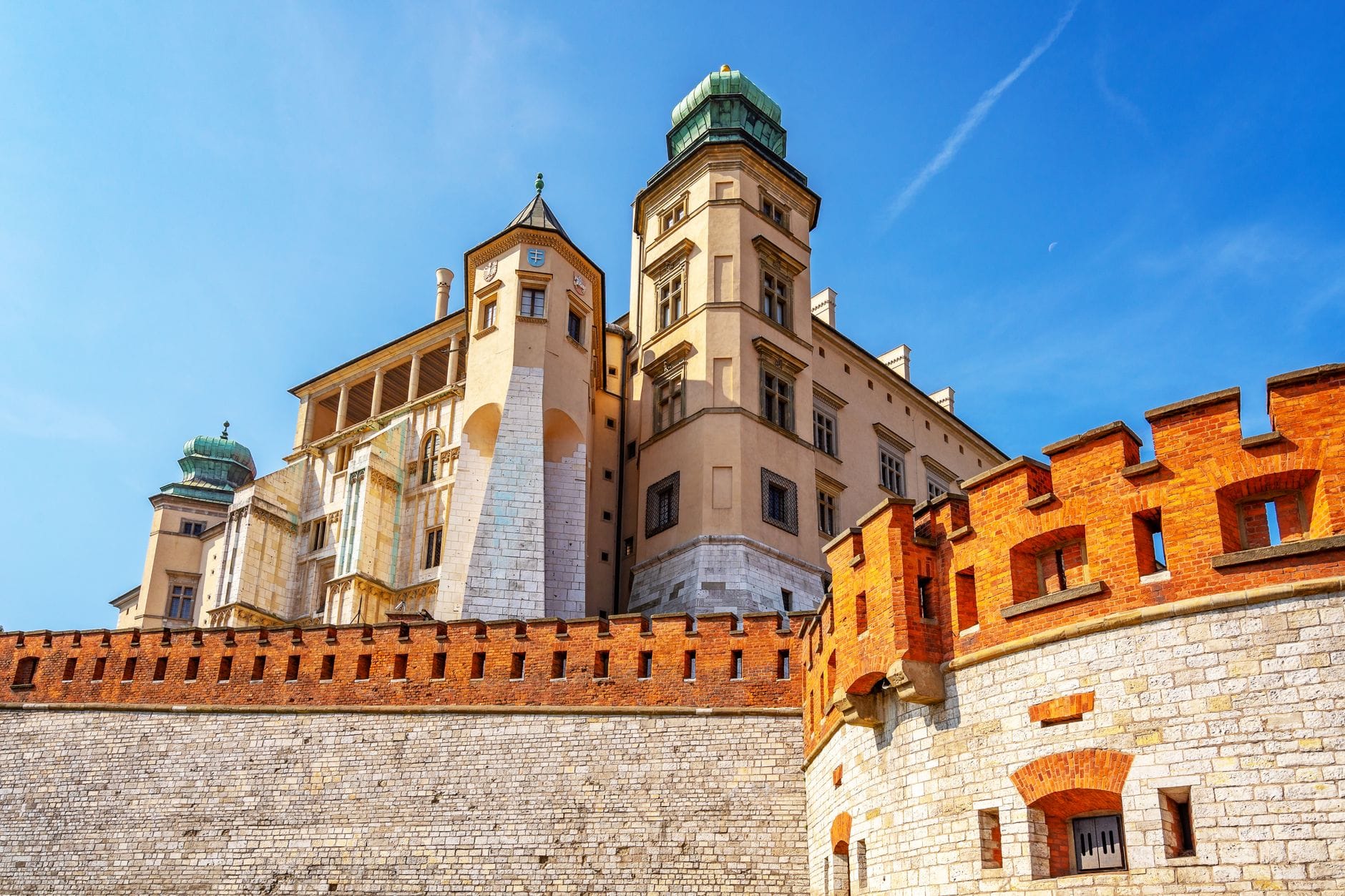 วิวของ Wawel ปราสาทหลวง ใน Kraków พร้อมหอคอย กำแพงป้องกัน และท้องฟ้าสีฟ้าแจ่มใส