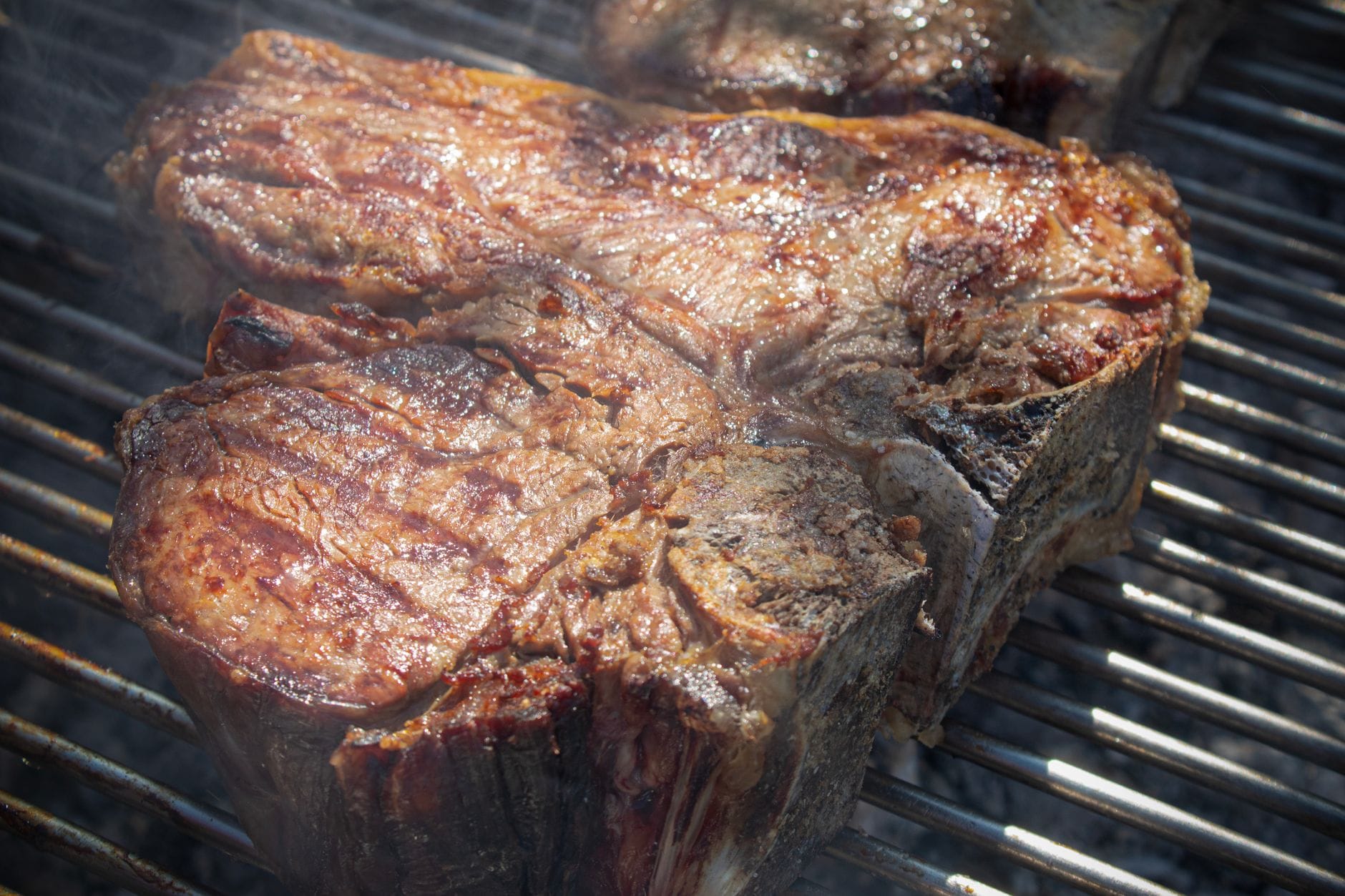 สเต็ก T-bone หั่นหนาย่างบนเปลวไฟแบบเปิด แสดงสไตล์คลาสสิกของ bistecca alla fiorentina