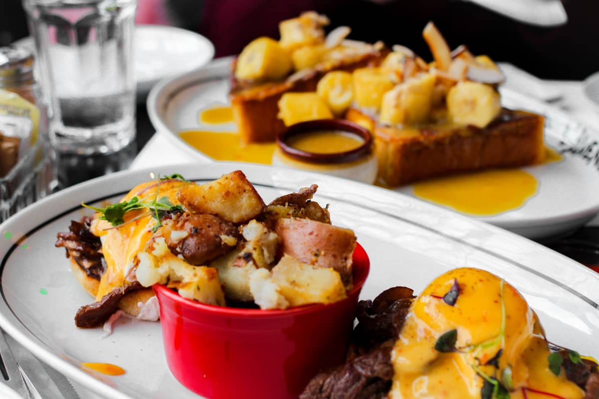 Nahaufnahme klassischer Montreal-Brunch-Teller in einem Restaurant mit Eiern, Kartoffeln und French Toast – ein Einblick in die vielfältige Esskultur der Stadt.
